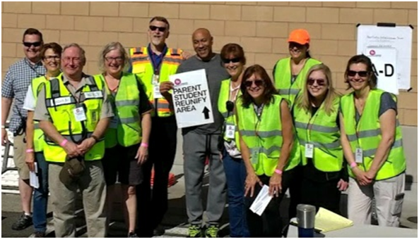 Photo depicting a group of adults in safety vests who participated in the parent-student reunification drill.